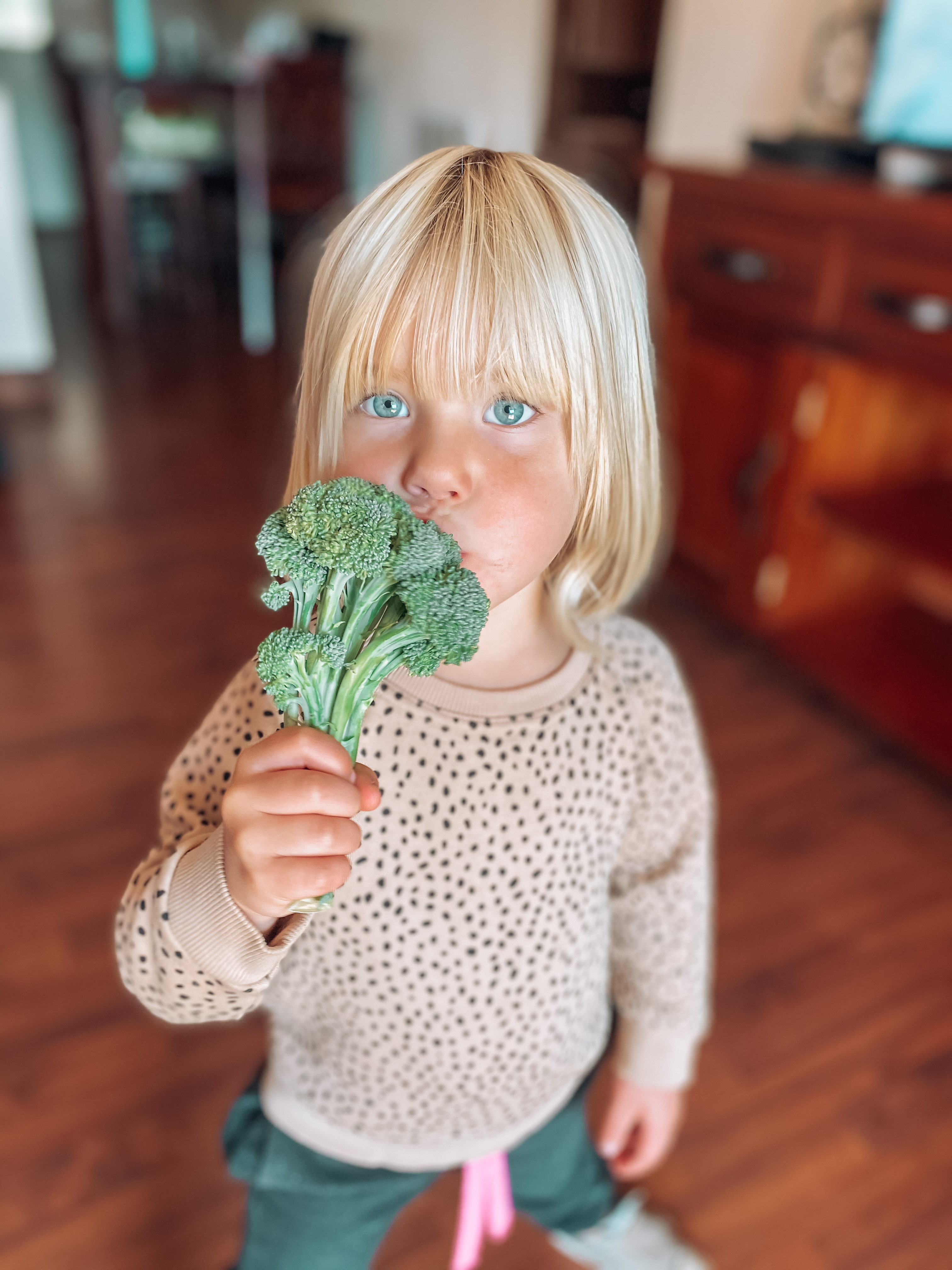 little girl eating broccoli